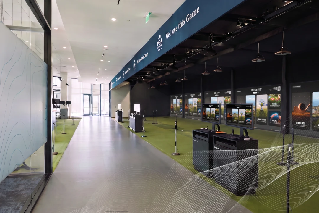 Modern golf simulator room with multiple screens, interactive stations, and a slogan "We Love this Game" displayed above.