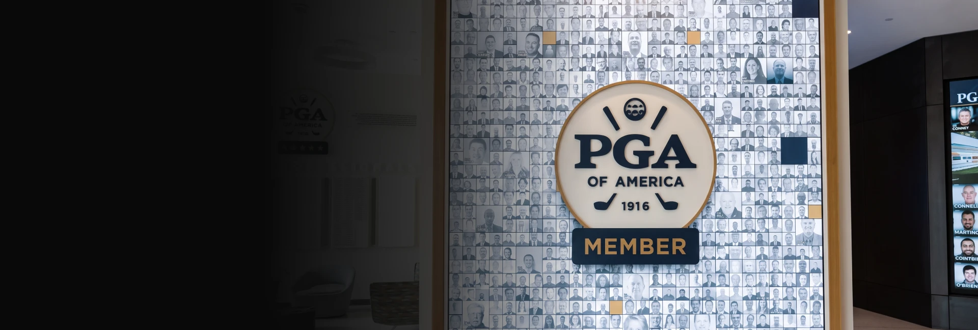 Wall display with a large PGA of America logo surrounded by a collage of black and white member photos.