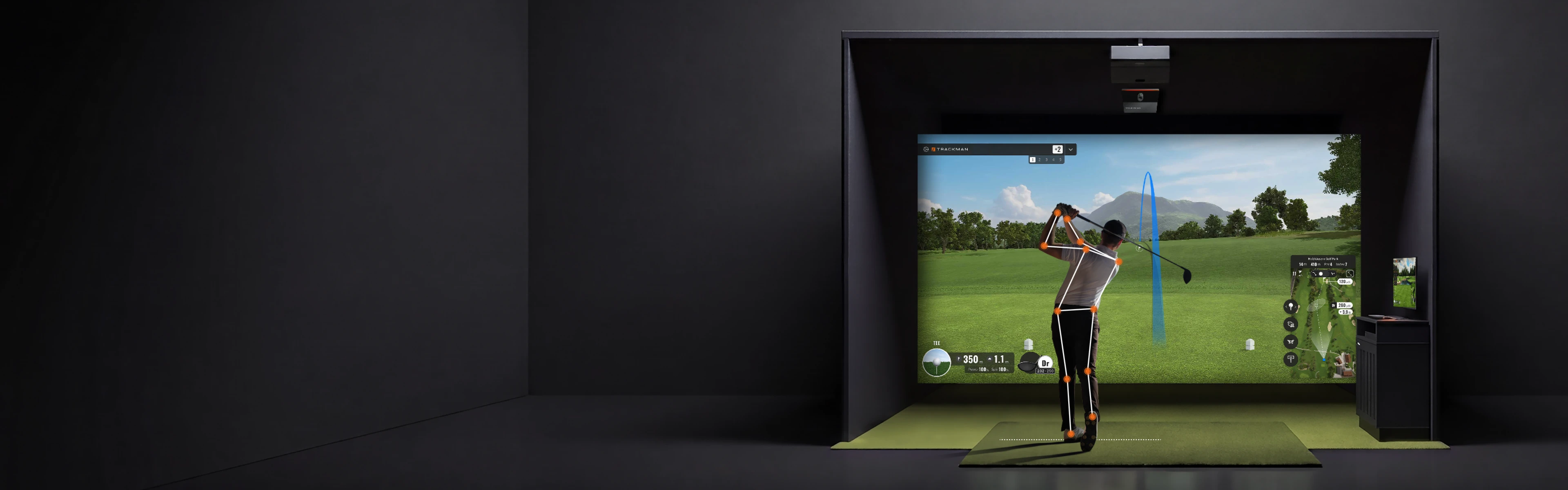 Golfer practicing in an indoor simulator, swinging club toward a projected virtual course on a screen, with graphics displaying trajectory and stats.