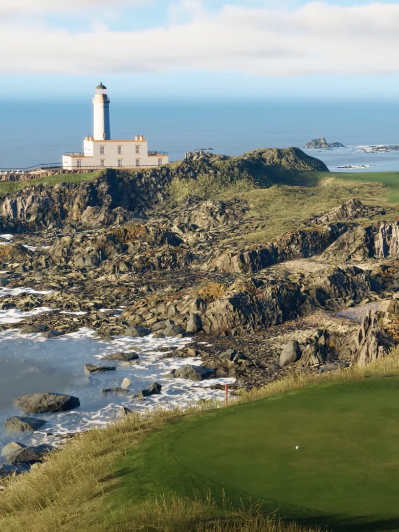 A lighthouse stands on a rocky coastline with a grassy golf course in the foreground and the ocean in the background under a partly cloudy sky.