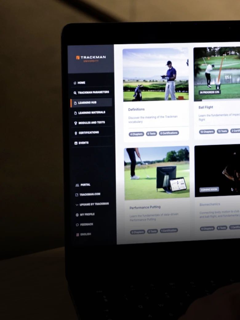 Laptop screen displaying a website with golf training content, including lessons and videos. The sidebar shows navigation options.