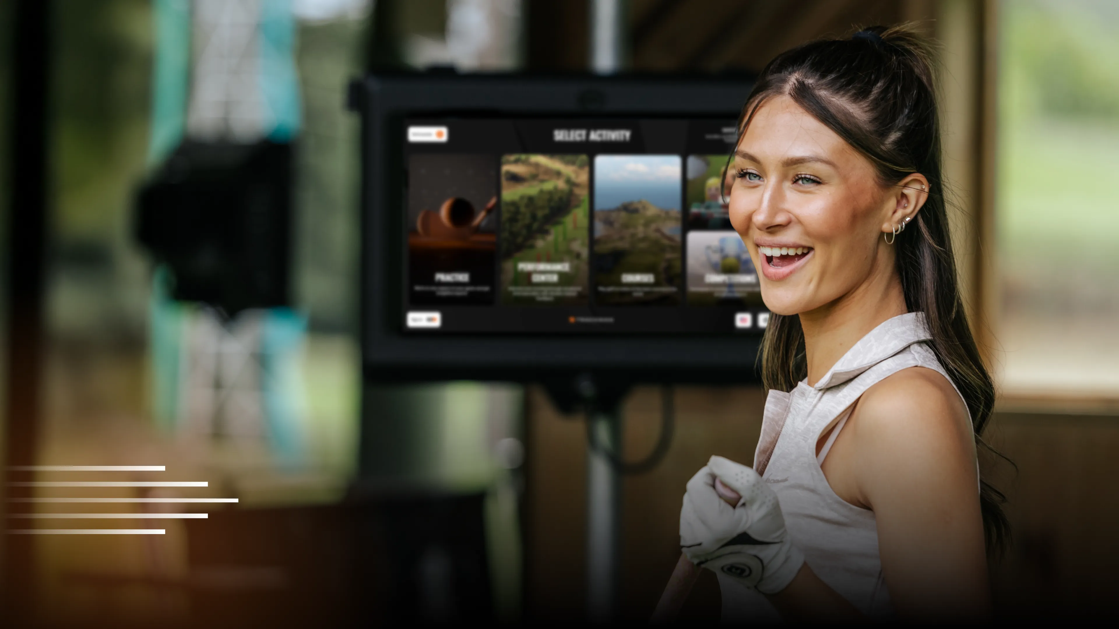 A woman smiling while wearing a white sleeveless top and a golf glove, with a digital screen displaying activity options in the background.