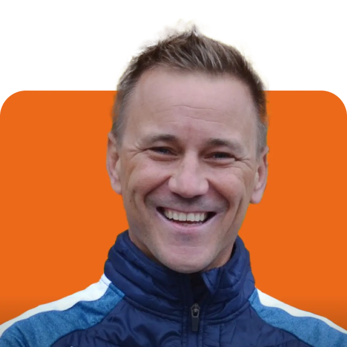 Smiling person in a blue jacket against an orange background.