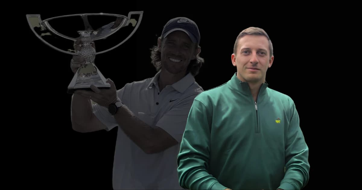 Tom Boys in a green jacket stands in front Tommy Fleetwood holding a trophy against a black background.
