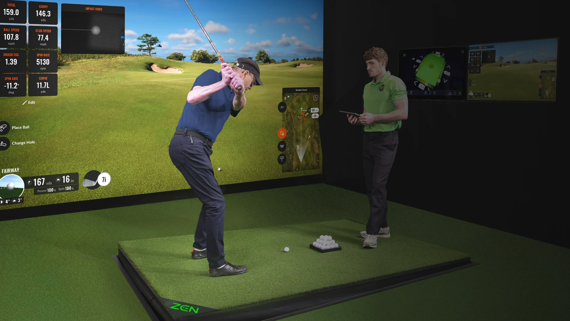 Golfer swings in a simulator room as an instructor observes, while data displays on screens in the background.