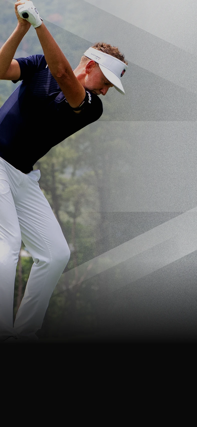 Ian Poulter mid-swing, wearing a navy shirt, white pants, and visor against a blurred background of trees.